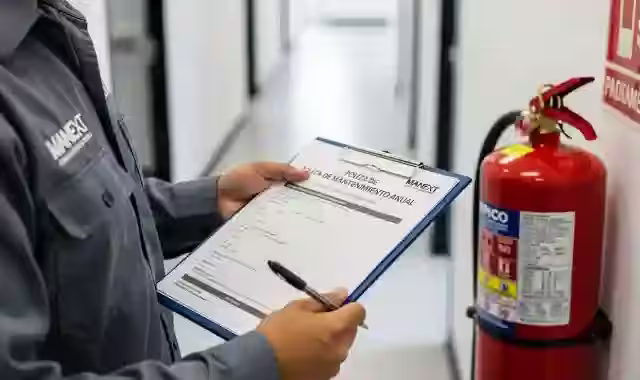 Documentos de póliza de mantenimiento anual de extintores sobre escritorio
